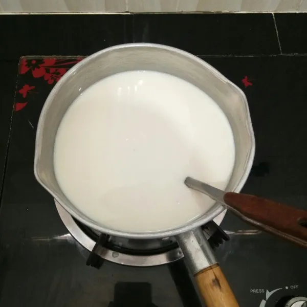 Campur semua bahan puding susu ke dalam panci. Masak sambil diaduk perlahan hingga mendidih. Angkat. Biarkan uap panasnya hilang.