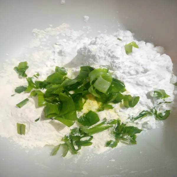 Campurkan tepung sagu dan tepung terigu, lalu tambahkan daun bawang, kaldu bubuk, dan garam. Kemudian aduk hingga rata.