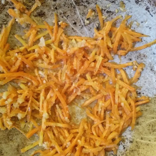Tumis bawang putih hingga harum, masukkan wortel. Masak selama 2 menit.