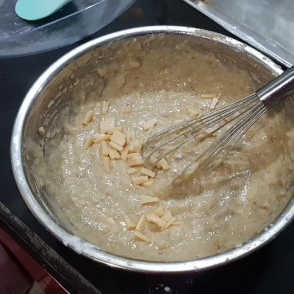 Tambahkan tepung ke dalam adonan pisang. Masukkan keju (sisakan sedikit untuk taburan). Aduk rata sebentar saja.