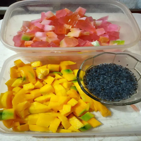 Siapkan buah mangga yang di potong dadu, jelly yang dipotong dadu, nata de coco, dan selasih yang sudah di rendam air panas.
