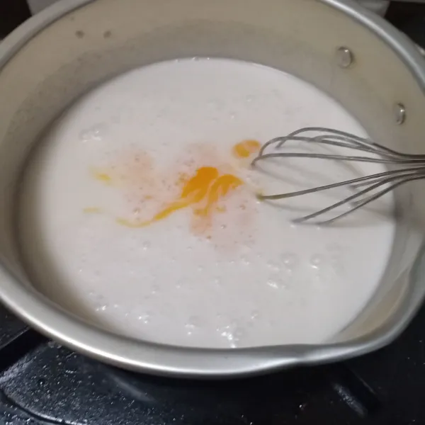 Campurkan susu, nutrijell, vanila essens, dan kuning telur. Aduk rata, lalu masak hingga mendidih.