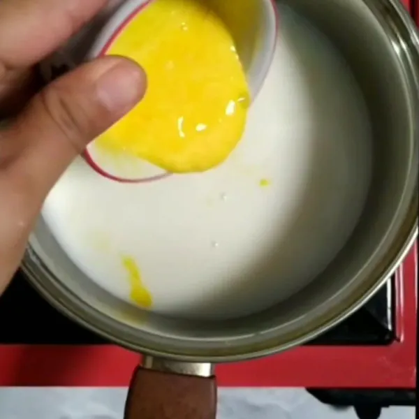 Ambil satu centong adonan pudding campurkan dengan kuning telur. Aduk cepat, kemudian masukkan ke dalam adonan pudding di dalam panci. Aduk cepat