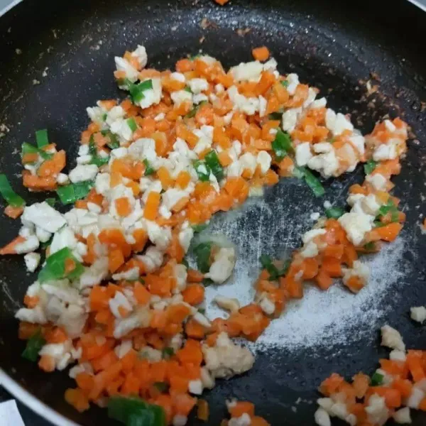 Panaskan minyak, masukkan bumbu halus tumis hingga harum. Masukkan ayam cincang dan wortel aduk-aduk hingga ayam berubah warna, kemudian tambahkan daun bawang.