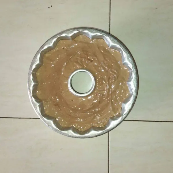 Olesi loyang dengan minyak goreng, lalu tuang adonan bolu ke dalam loyang, ratakan adonannya.