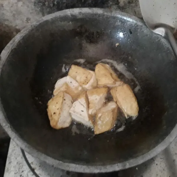 Potong segitiga tahu, kemudian goreng hingga setengah matang.