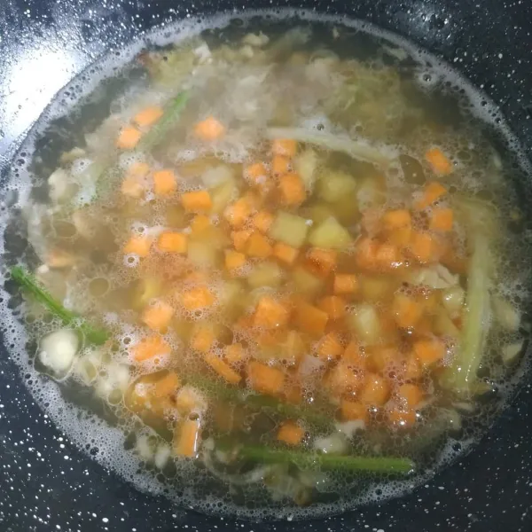Setelah harum, masukkan kaldu udang. Tunggu mendidih masukkan wortel dan kentang.