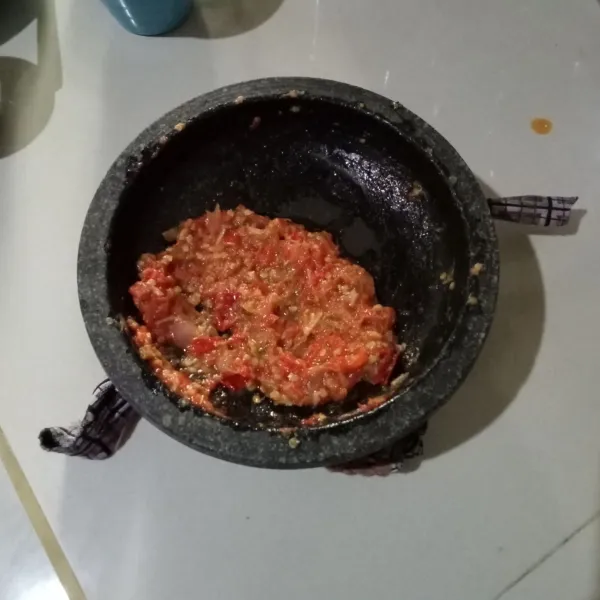 Goreng bahan sambal kemudian haluskan. Tambahkan gula pasir, garam dan kaldu bubuk secukupnya. Penyet ayam goreng di atas sambal.