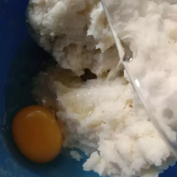 Lalu masukan telur. Aduk lagi sampai rata, lalu masukan tepung tapioka. Aduk dengan tangan.