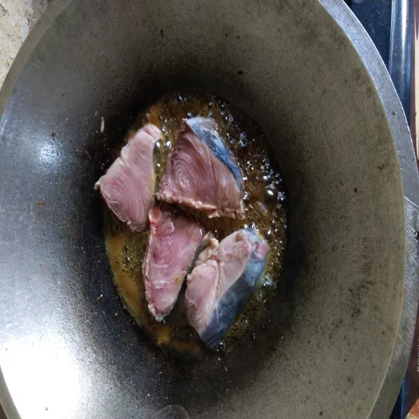Panaskan secukupnya minyak goreng, lalu goreng ikan tuna sampai setengah matang.
