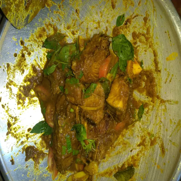 Masukkan ikan tuna yang sudah digoreng tadi, bumbui dengan garam, gula pasir dan kaldu jamur. Aduk rata dan cek rasa. Masak hingga bumbu meresap dan airnya surut. Terakhir masukkan potongan tomat dan kemangi. Aduk rata, masak sebentar. Matikan api. Siap disajikan.