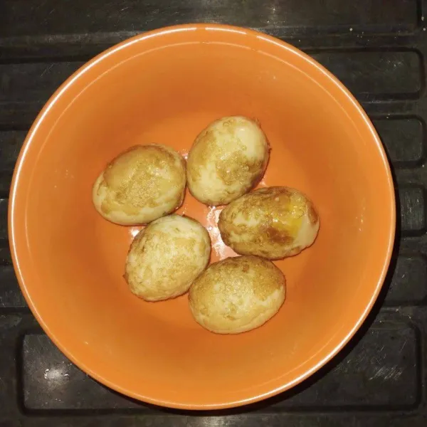 Jika sudah kuning keemasan, angkat telurnya dan sisihkan.