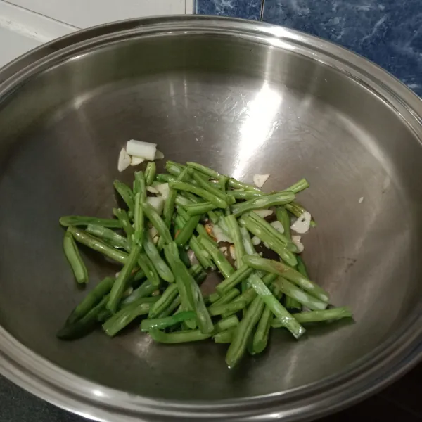 Potong buncis dan belah menjadi 2 bagian, Kemudian tumis bersama dengan bawang putih hingga layu.