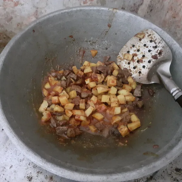 Masukkan kentang dan ati ampela. Tambahkan 50 ml air, kemudian aduk rata.