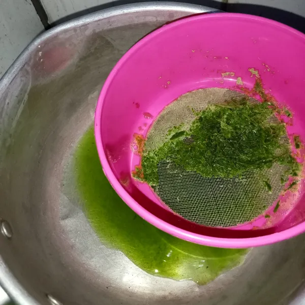 Saring jus daun pandan ke dalam panci.