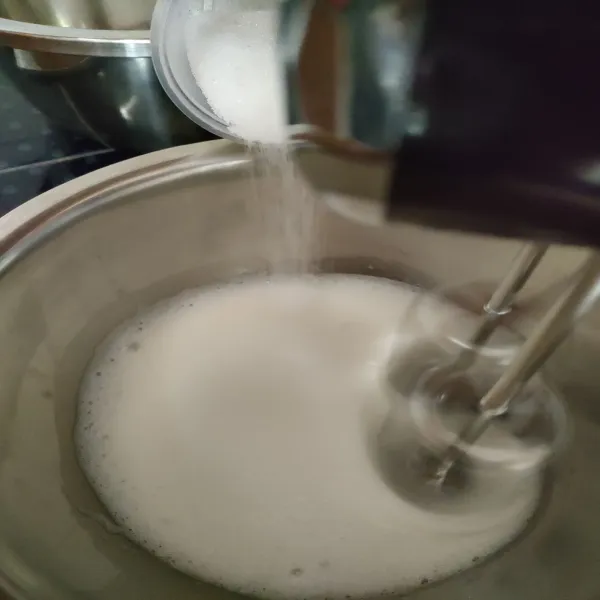 Masukkan gula kastor secara bertahap sambil dimixer dengan kecepatan sedang. Mixer hingga soft peak atau jika diterbalikkan tidak tumpah.