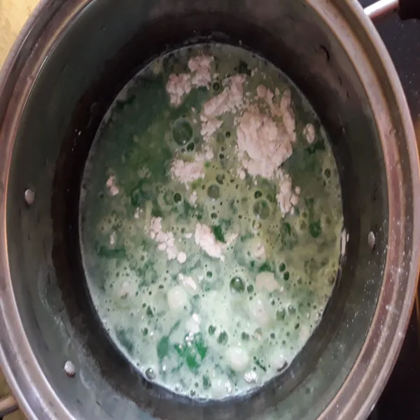 Tuang jus pandan dalam panci berisi tepung beras dan santan. Tambahkan garam.