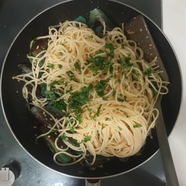 Masukkan spaghetti dan daun parsley, aduk rata dan masak selama 2 menit.