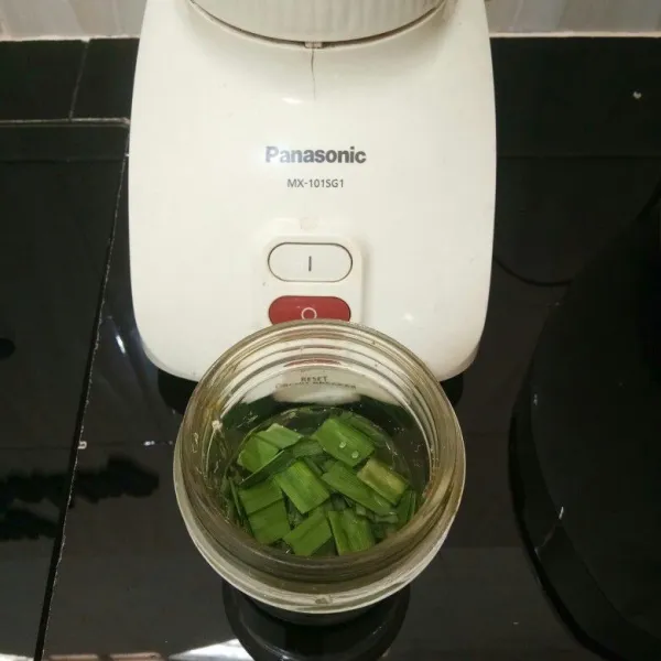 Potong-potong daun pandan dan daun suji. Masukkan ke dalam blender dan tambahkan 100 ml air.
