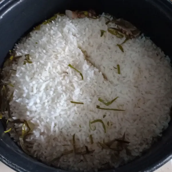 Masak beras sampai matang di rice cooker.