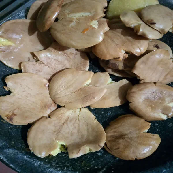 Setelah di rebus, pipihkan jengkol menggunakan ulekan atau palu.