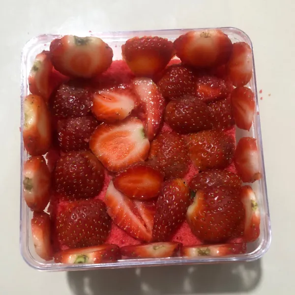 Potong-potong strawberry, kemudian tata diatas cake dalam dessert box.