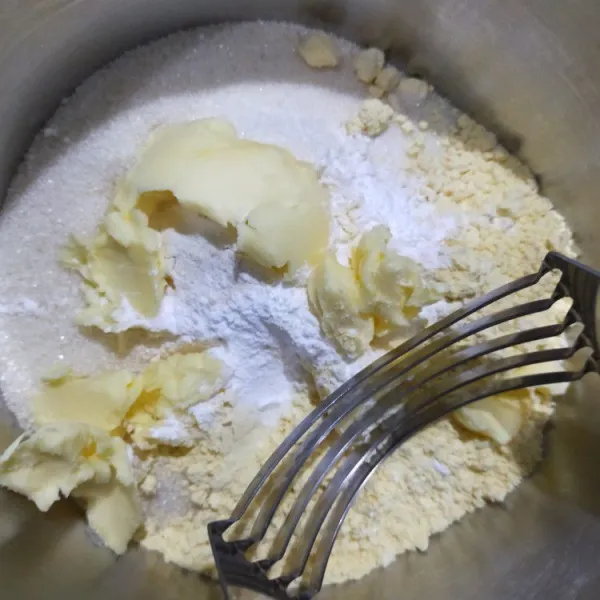 Masukan mentega dingin. Aduk rata dengan garpu/pisau pastry hingga adonan berbulir.