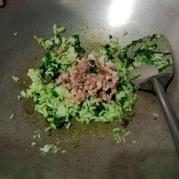 Kemudian masukkan nasi dan air pandan. Aduk. Lalu masukkan daging. Aduk kembali