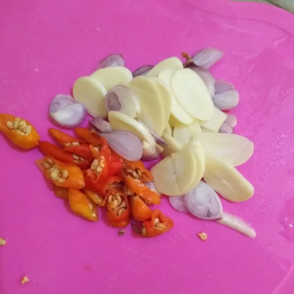 Iris tipis bawang merah, bawang putih, dan cabai rawit.