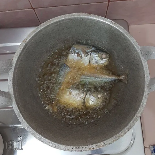 Goreng ikan kembung hingga berubah warna dan garing.