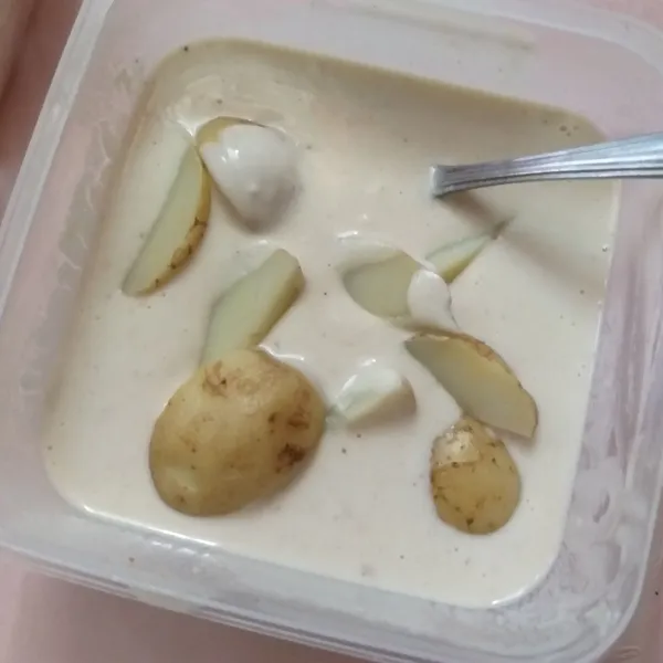 Masukkan kentang ke dalam adonan basah, lalu ratakan.