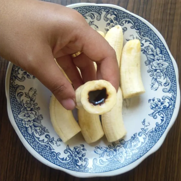 Isi pisang dengan cokelat leleh, lalu tutup menggunakan potongan pisang.