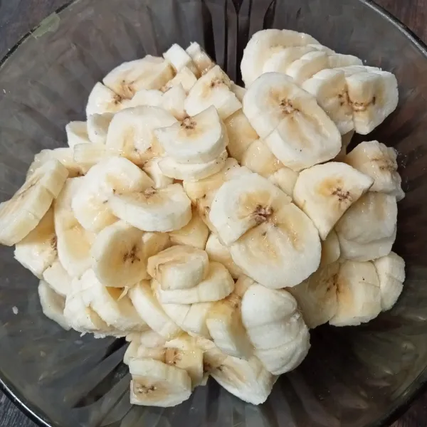 Kupas pisang dan belah dua, lalu potong-potong.