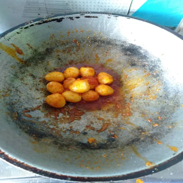 Tambahkan telur puyuh yang sudah di goreng tadi, lalu aduk sampai semua bumbu menempel pada telur puyuh.
