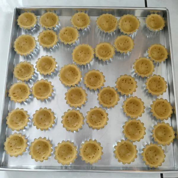 Tusuk-tusuk dengan garpu agar adonan tidak menggembung, lalu oven di suhu 150°C api atas bawah selama 20 menit (oven sudah dipanaskan terlebih dahulu). Keluarkan dari oven, lalu keluarkan dari cetakan.