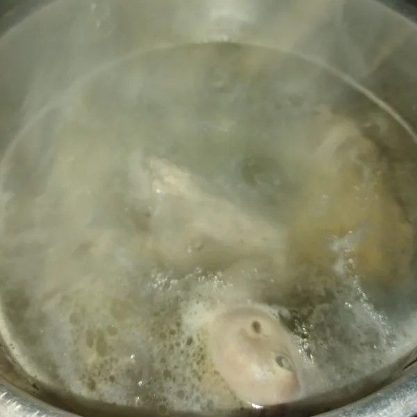 Cuci bersih daging ayam, lalu siapkan panci, masukkan daging ayam dan air, lalu rebus hingga mendidih dengan api besar, jika sudah benar-benar mendidih, kecilkan apinya, di sini air masih tetap mendidih walaupun pakai api kecil, lalu buang buih-buih yang ada di pinggiran panci, rebus daging ayam dengan api kecil sekitar setengah jam.