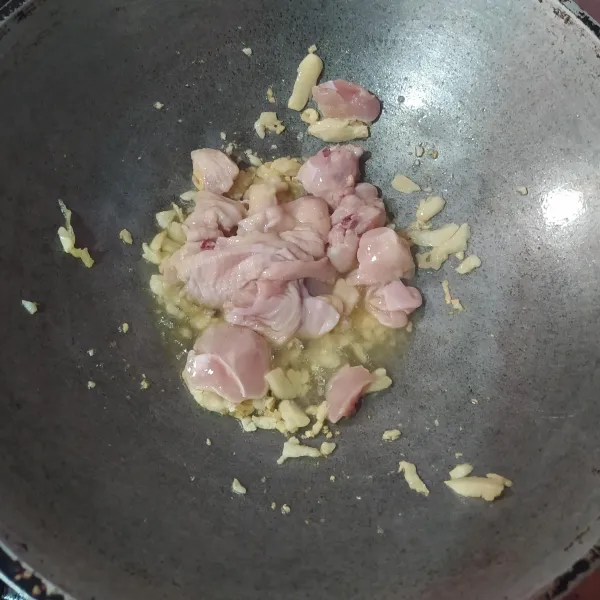 Bawang putih dicincang halus, kemudian tumis hingga harum. Masukkan ayam yang sudah dipotong kecil-kecil. Tumis hingga ayam berubah warna.