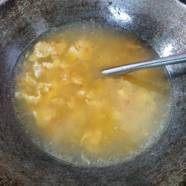 Setelah bumbu matang, masukkan telur goreng orak-arik, kemudian masukkan air bumbui dengan garam, gula, lada dan kaldu bubuk. Masak sampai mendidih.