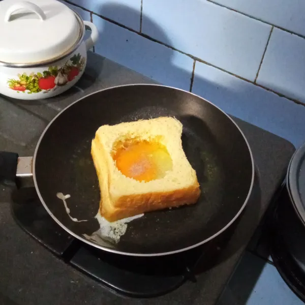Masukkan telur bagian tengah roti. Bumbui lada garam.
