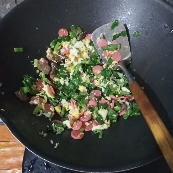 Masukkan telur orak-arik, irisan daging, sosis, daun bawang, seledri dan sawi. aduk hingga layu.