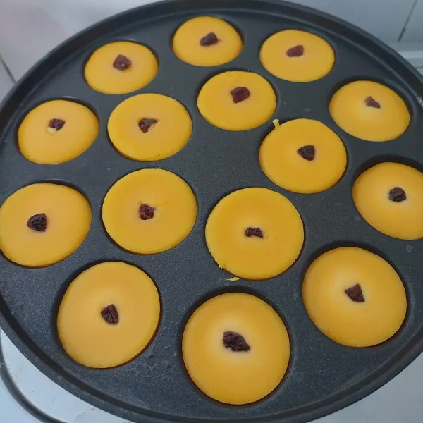 Setelah ½ matang, beri hiasan dengan kismis. Kemudian tutup kembali dan masak sampai lumpur matang (pinggiran terlihat kecoklatan). Keluarkan dari cetakan, sajikan.