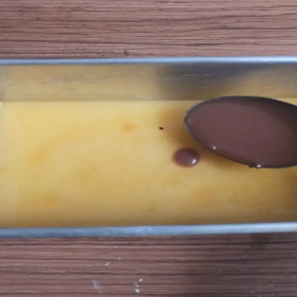 Tuang lapisan coklat perlahan setelah lapisan bening mulai set. Setelah lapisan coklat berkulit, tuang lagi sisa lapisan bening. Tunggu hingga berkulit.