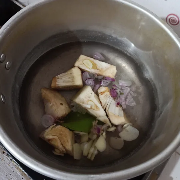 Rebus air, bawang merah, bawang putih, tewel yang sudah direbus dan daun salam, sampai mendidih.