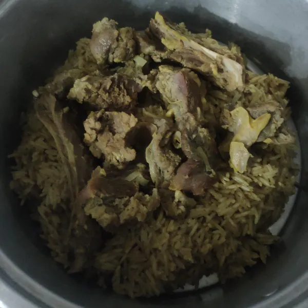 Panaskan kukusan, pindahkan nasi yang sudah di aron, kukus nasi selama 20 menit api sedang, kukus bersama daging diatasnya, matikan.