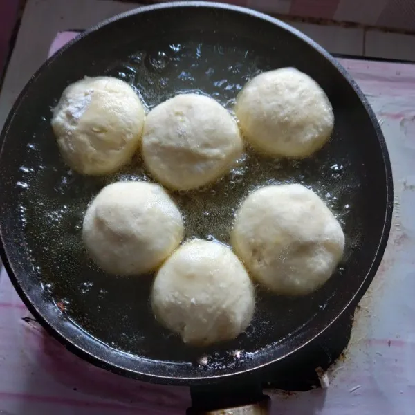 Panaskan minyak dengan api sedang, goreng donat hingga mengembang dan kuning keemasan. Sajikan donat dengan gula halus atau topping lainnya sesuai selera.