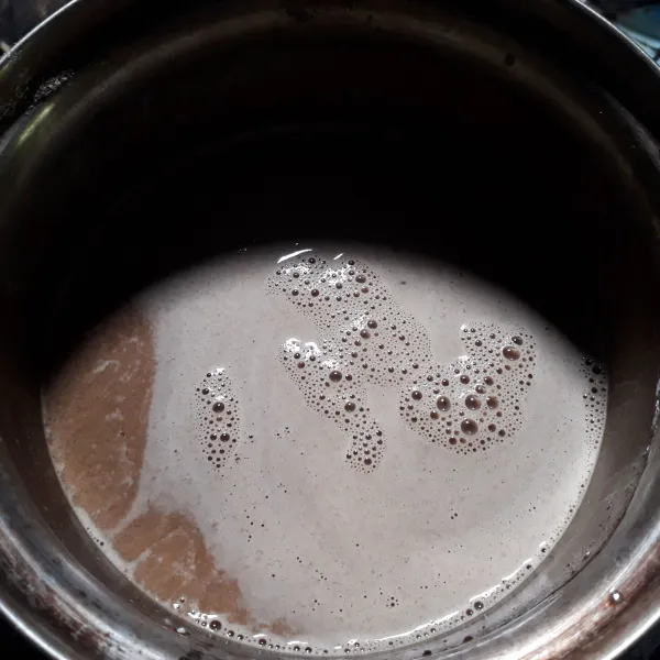 Masukkan larutan susu kental manis dan bahan puding lainnya ke dalam panci, lalu aduk rata.