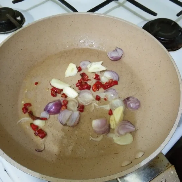Tumis irisan bawang merah, bawang putih, dan cabai merah keriting hingga harum.