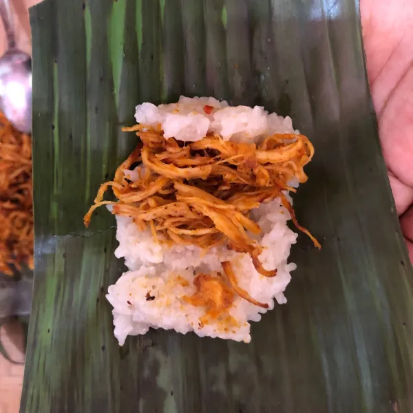 Potong daun pisang yang telah disangrai, lalu susun ketan dan ayam kemudian bungkus dengan daun pisang.