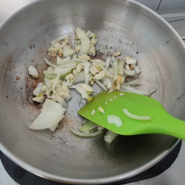 Tumis bawang putih hingga harum, masukkan bawang bombay, tumis hingga layu.