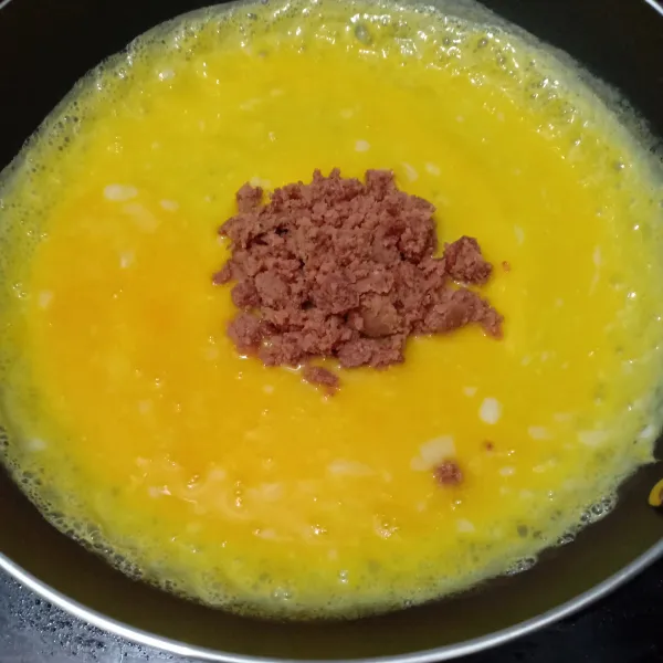 Kocok telur, dadar seperti biasa, tambahkan kornet di tengahnya.
